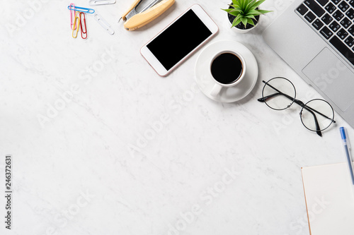 Stylized marble office working desk with smartphone  laptop  glasses and coffee  workspace design  mock up  topview  flatlay  copyspace  closeup