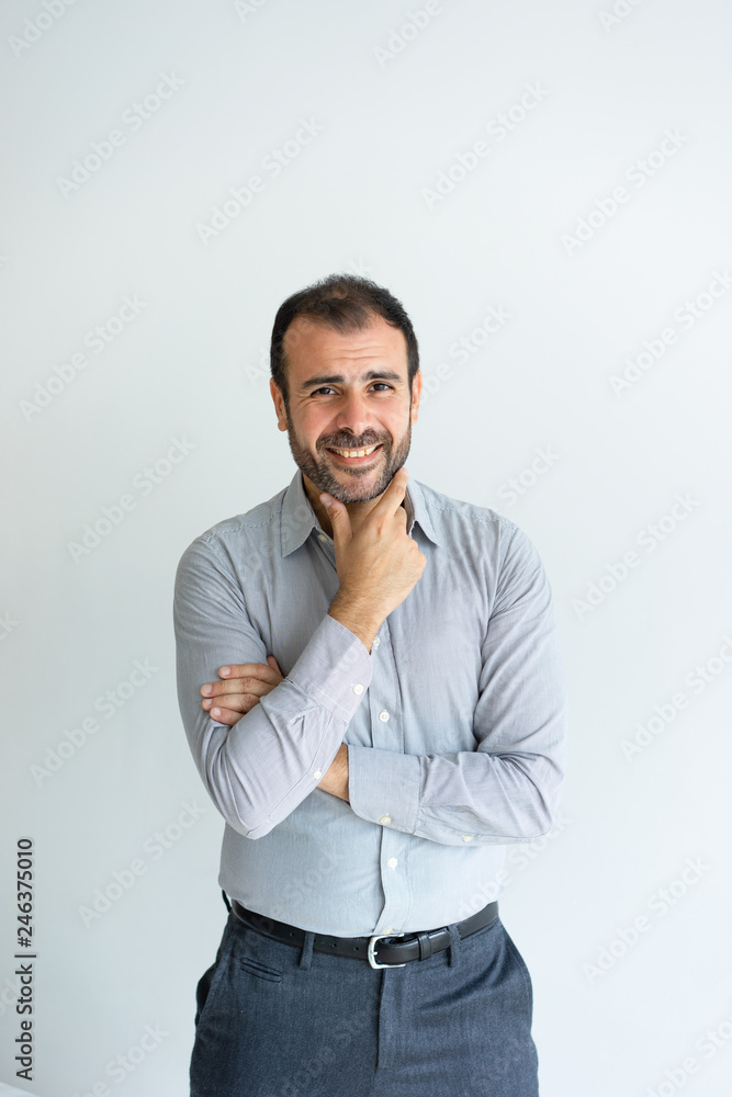 Smiling handsome man touching chin and looking at camera. Pensive middle-aged guy standing. Positive man concept. Isolated front view on white background. Smiling handsome man touching chin and looking at camera. Pensive middle-aged guy standing. Positive man concept. Isolated front view on white background.