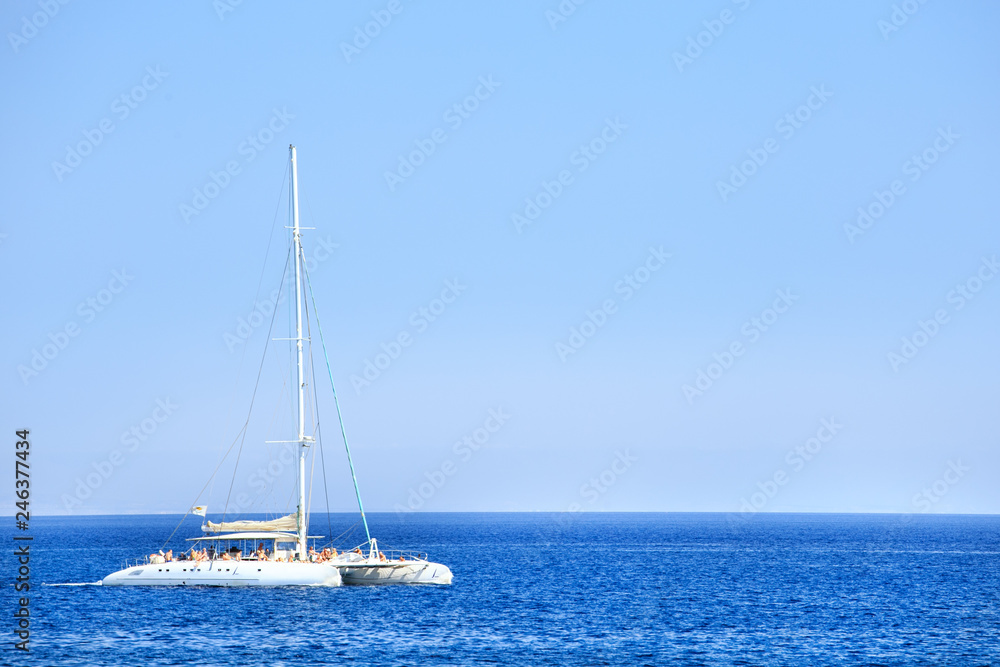 Obraz premium Catamaran with tourists with blue sky and water. Vacation background.
