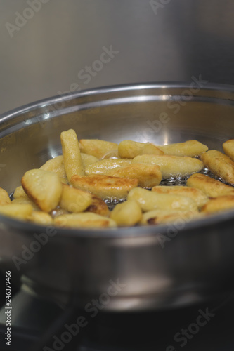 Sticks of dough and potatoes fry with butter in a frying pan © Vitaliy