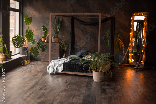 loft style dark bedroom with green plants and textured wall