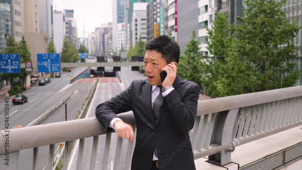 Japanese businessman talking on a cell phone. Japanese businessman talking on a cell phone.