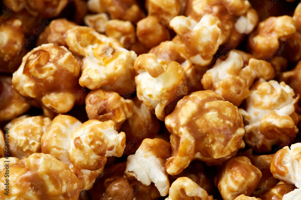 caramel pop corn background. Golden caramel popcorn close up. Background of popcorn. Snacks and food for a movie caramel pop corn background. Golden caramel popcorn close up. Background of popcorn. Snacks and food for a movie