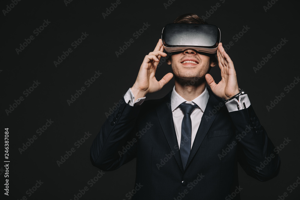 smiling businessman in virtual reality headset isolated on black smiling businessman in virtual reality headset isolated on black