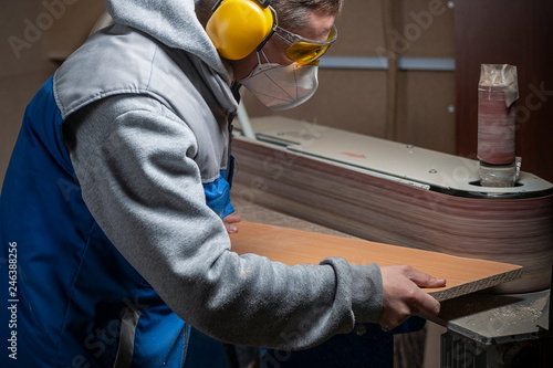 Obraz na płótnie man in safety glasses, headphones and a respirator work for a grinding machine w salonie