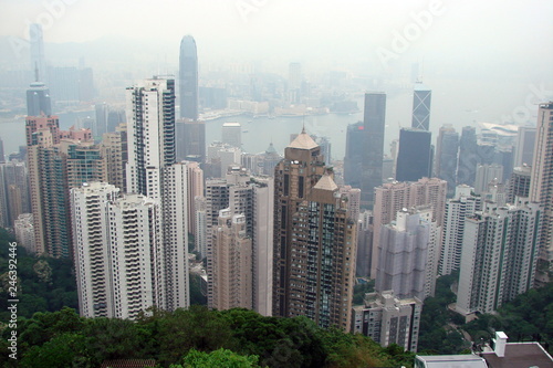 Panorama from the top of a hill of modern areas of the Asian metropolis with high skyscrapers on the coast of the Gulf covered by fog.