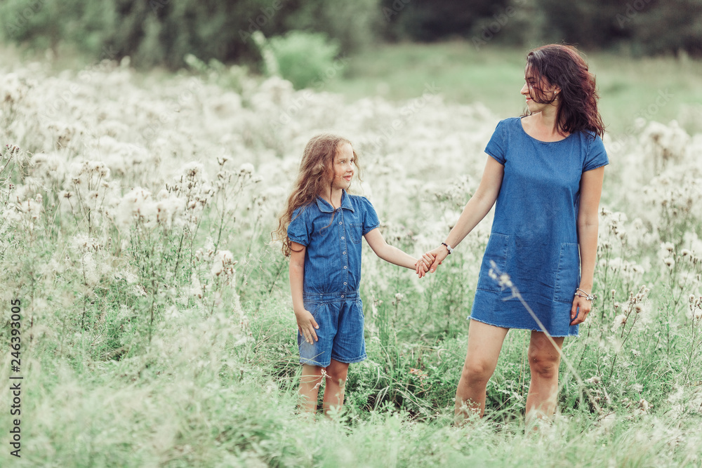 Happy mother and daughter outdoors in the summer having fun together. Motherhood, love, family, happiness concept Happy mother and daughter outdoors in the summer having fun together. Motherhood, love, family, happiness concept