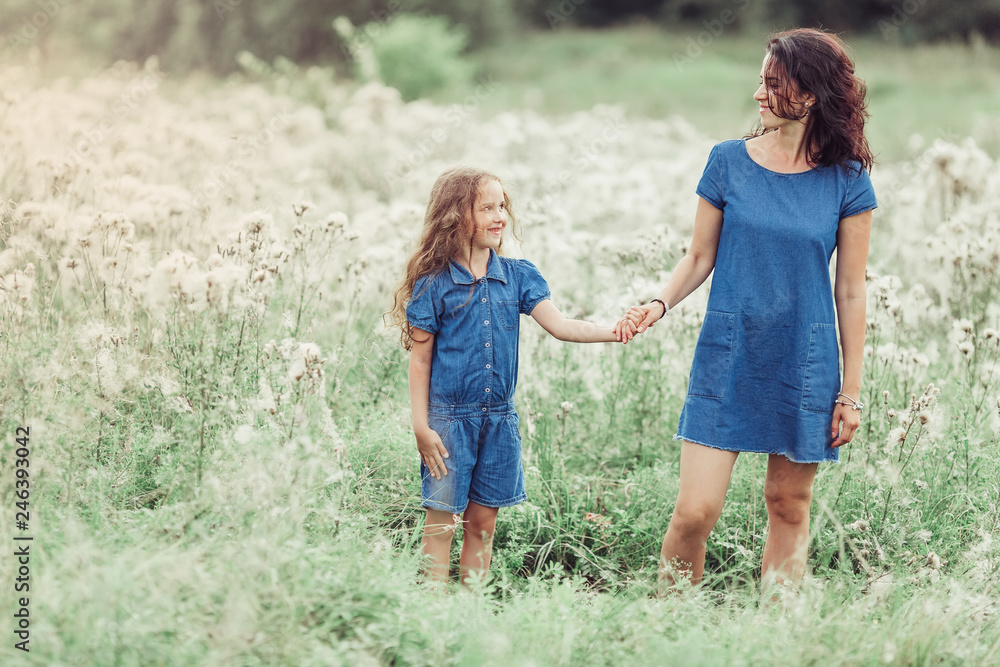 Happy mother and daughter outdoors in the summer having fun together. Motherhood, love, family, happiness concept Happy mother and daughter outdoors in the summer having fun together. Motherhood, love, family, happiness concept