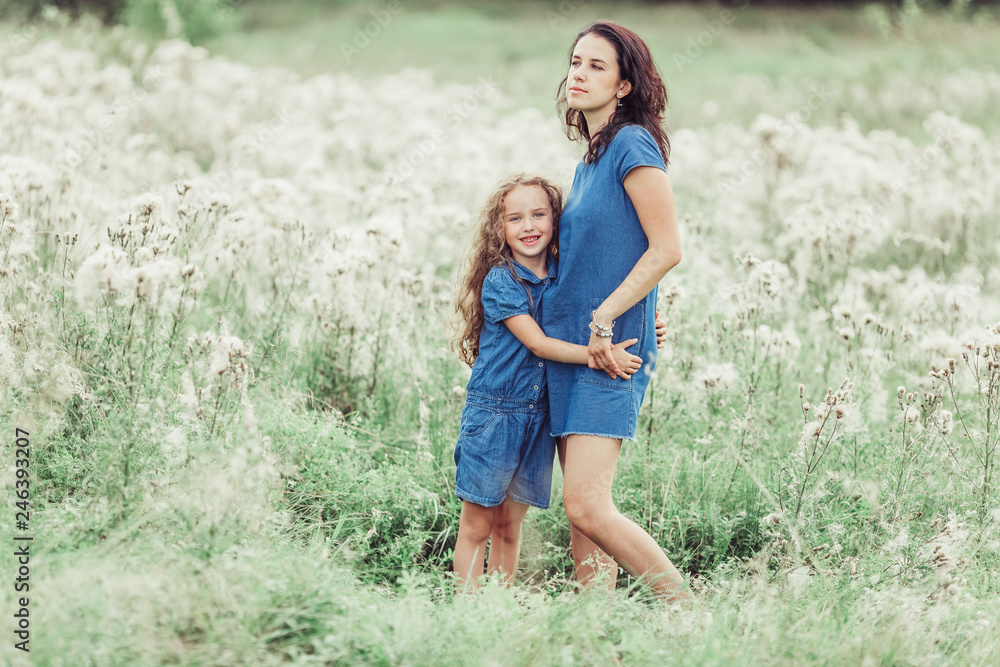 Happy mother and daughter outdoors in the summer having fun together. Motherhood, love, family, happiness concept Happy mother and daughter outdoors in the summer having fun together. Motherhood, love, family, happiness concept