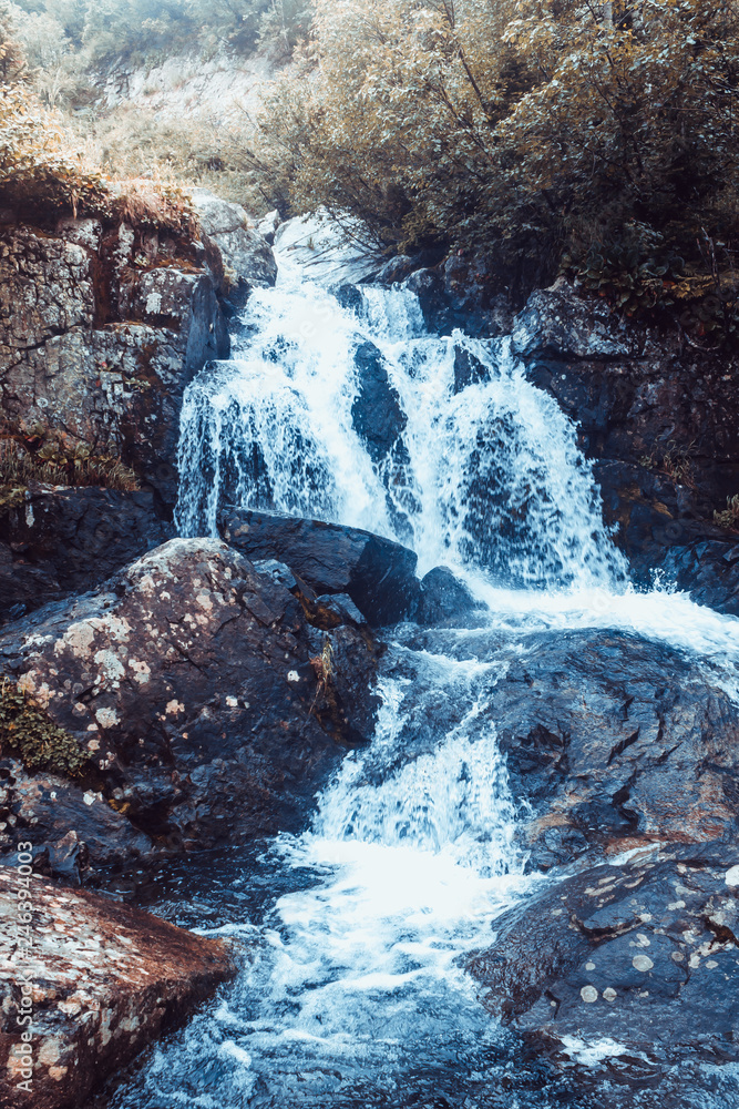 Waterfall in mountains. Rapid flow in river. Water in rocks, trip along river. Waterfall in mountains. Rapid flow in river. Water in rocks, trip along river.
