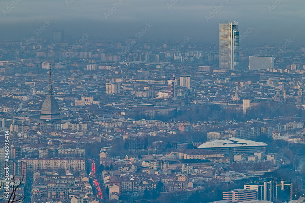Panoramic view at sunrise on Turin city seen from Superga in winter, with a layer of smog that falls on buildings