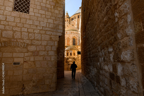 Silhouette of a tourist walking in an alleyway in the Old City of Jerusalem, Israel. The Old City is a 0.9 square kilometres walled area within the modern city of Jerusalem.
