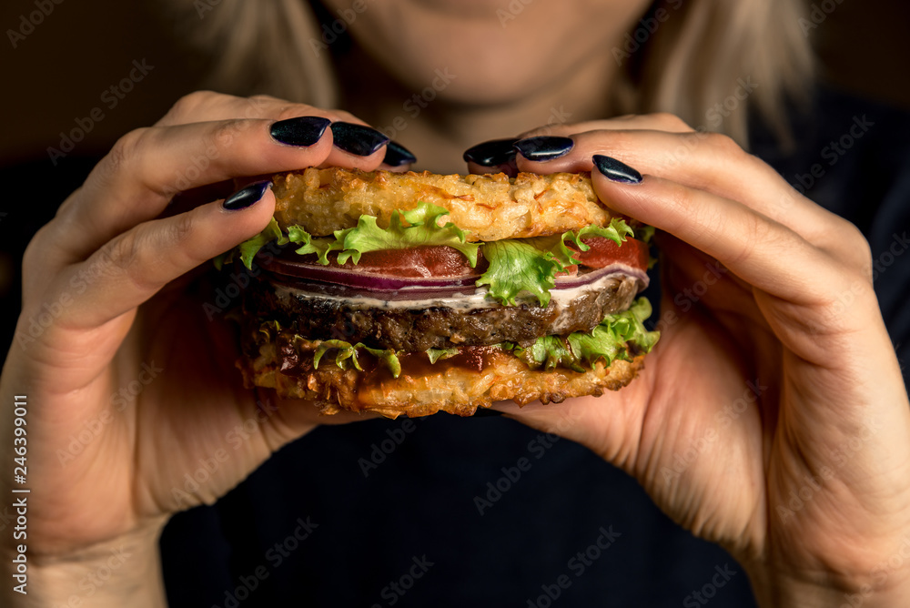 Healthy lifestyle, proper nutrition. Healthy rice burger with vegetables, herbs and cutlet in female hands