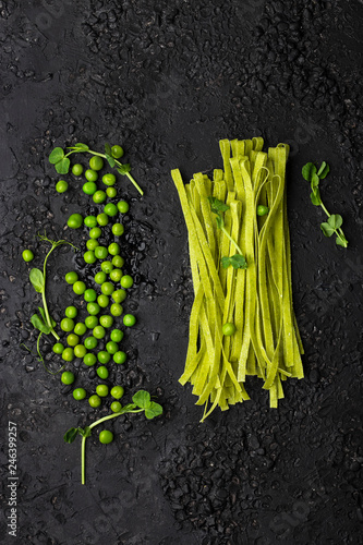 homemade Tagliatelle pasta with mashed green peas on a black background