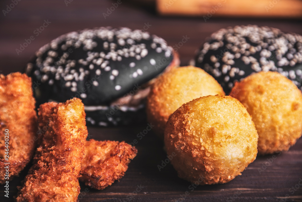 Nuggets and black burger on wooden background