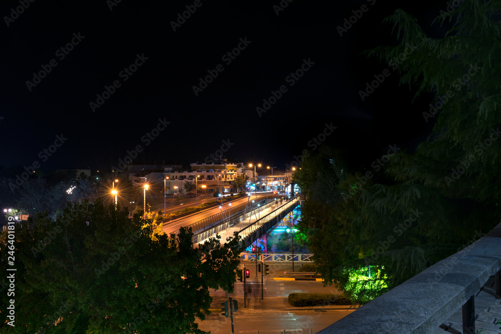 The bridge of the Pinios River and the roundabout in a night photo. Light painting from car lights. In the city of Larissa