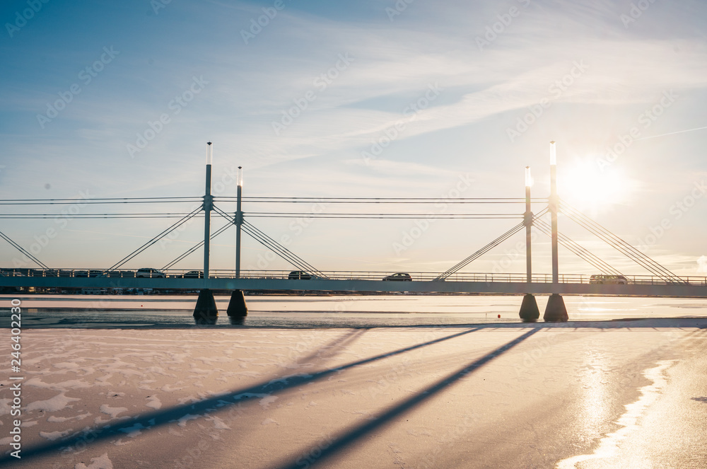 A bridge that goes over the frozen lake. Sunny winter day.
