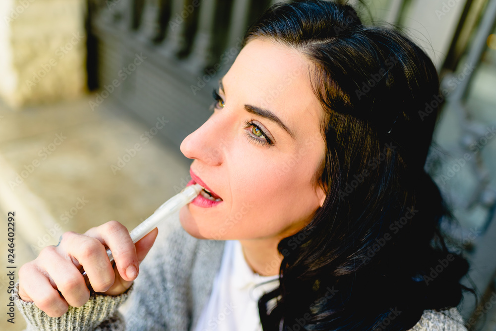 Portrait of brunette woman with thoughtful face, 30s, standing at the city in winter looking away, thinking. Portrait of brunette woman with thoughtful face, 30s, standing at the city in winter looking away, thinking.