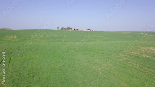 Aerial footage of a farm at the edge of a Badlands terrain. photo