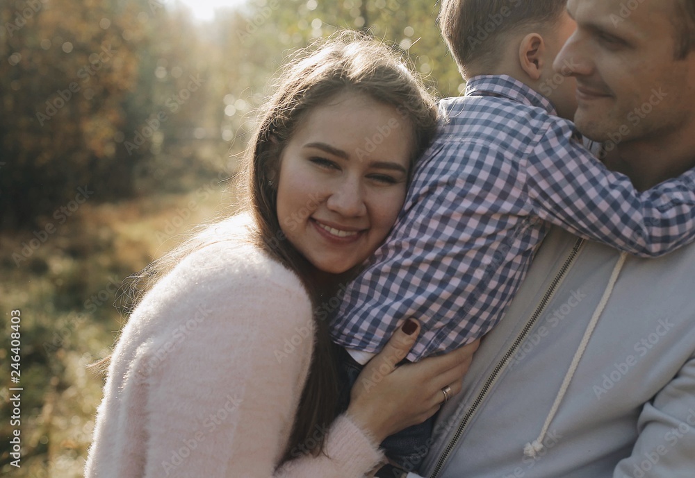Mom leaned on the back of her son. Boy in his father's arms Mom leaned on the back of her son. Boy in his father's arms