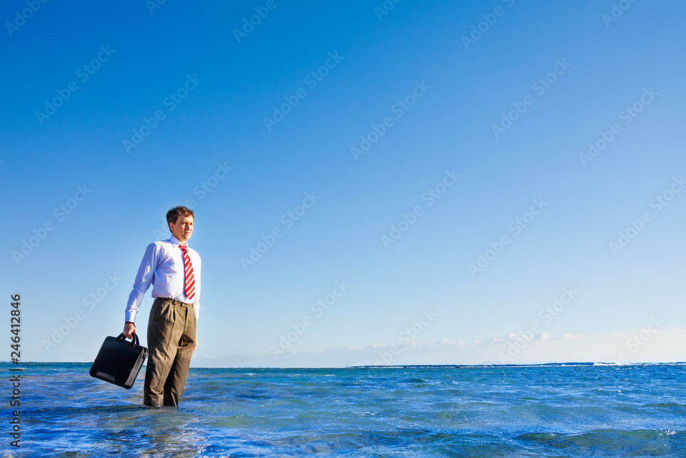 Young office white collar worker stand in the sea