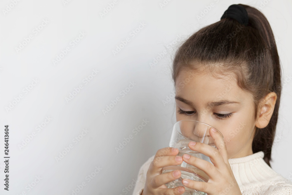 Happy child girl drinking pure water from glass. Happy child girl drinking pure water from glass.