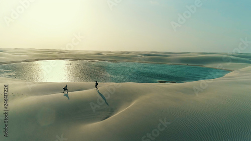 Friends walking in the dunes in Lençois Maranhenses, Brazil photo