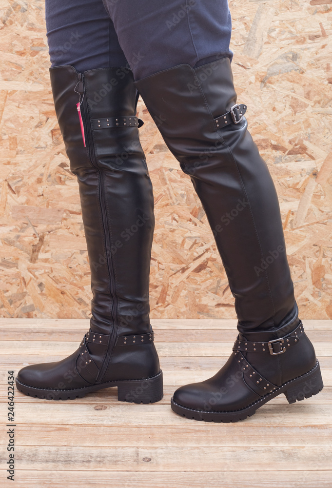 Lady's footwear, Leather high boots over wood background Lady's footwear, Leather high boots over wood background