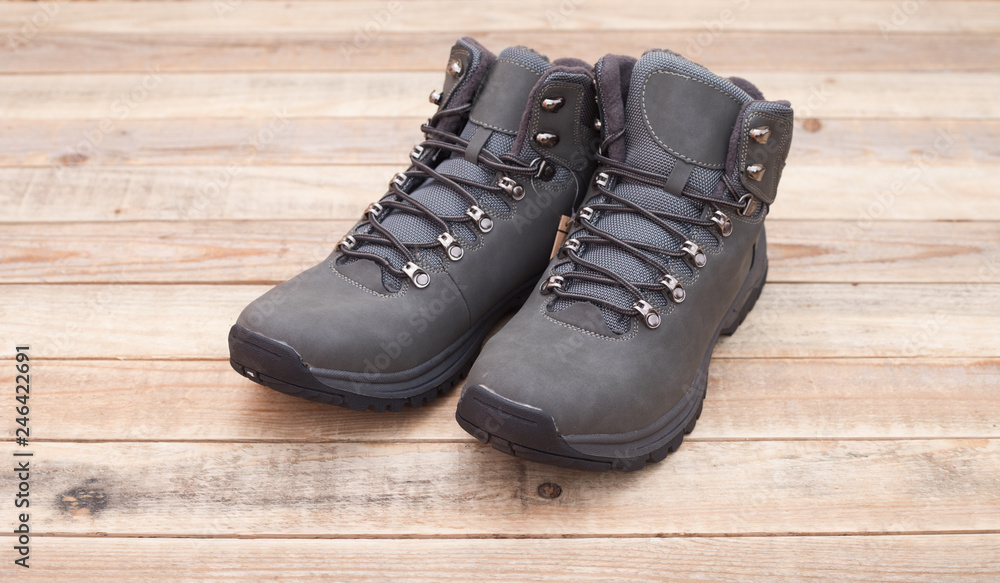Leather boots with fur lining at wood background, close-up Leather boots with fur lining at wood background, close-up