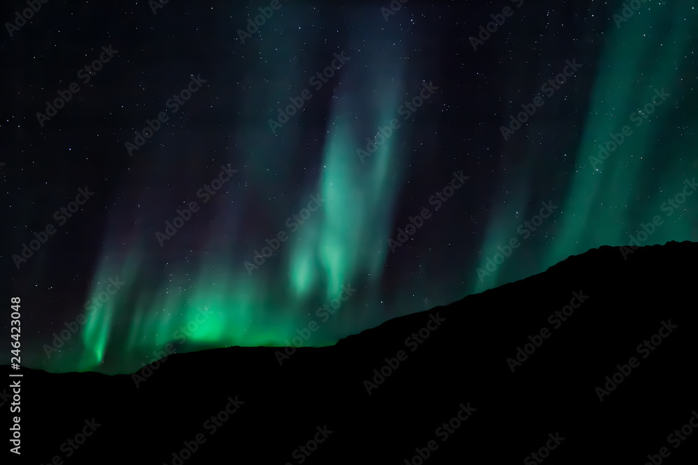 Amazing Aurora Borealis in North Norway (Ringvassoy), mountains and sea in the background
