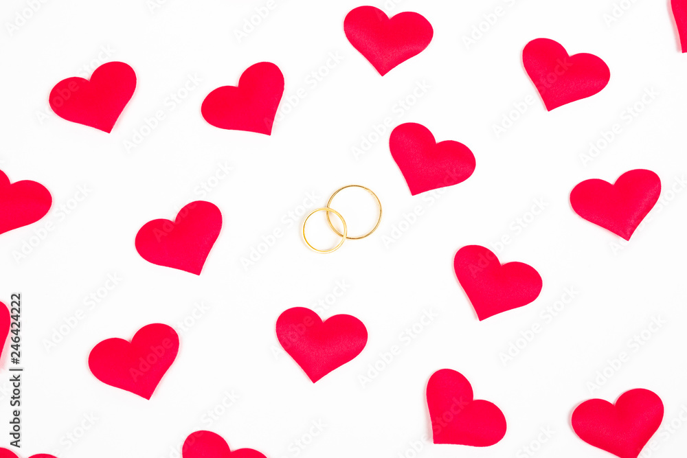 Dos anillos de boda entre corazones