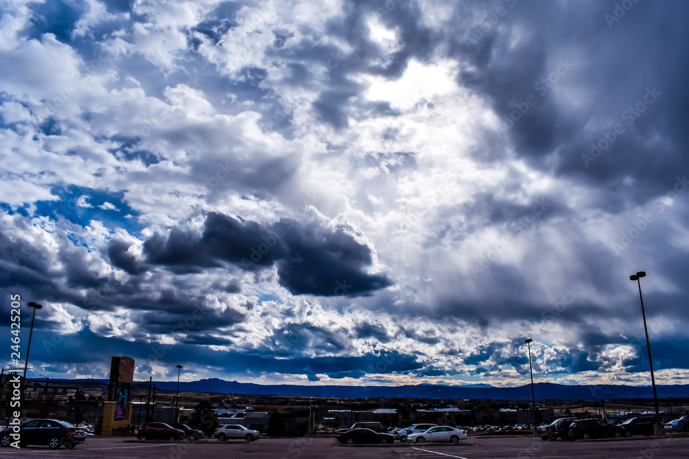 a wide view of sky, clouds and mountain from parking lot at Colorado springs a wide view of sky, clouds and mountain from parking lot at Colorado springs