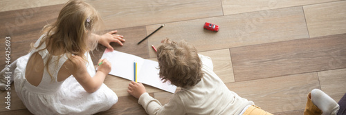 Horizontal top above photo little children preschool brother sister drawing on warm wooden floor play spend free time at modern home together, banner for website header design with copy space for text photo