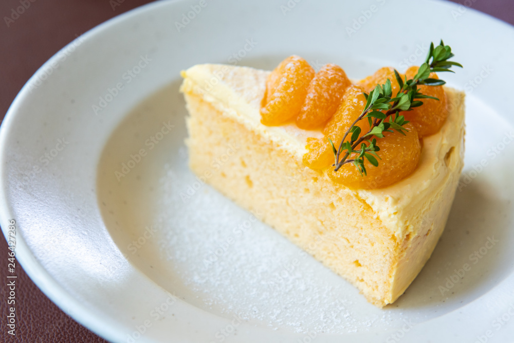 orange cake with orange fruit topping on white dish orange cake with orange fruit topping on white dish