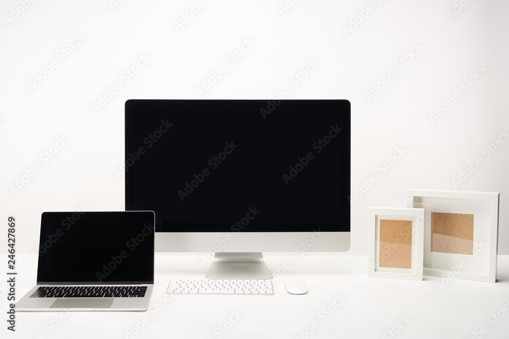 workplace with photo frames, desktop computer and laptop with copy space isolated on white workplace with photo frames, desktop computer and laptop with copy space isolated on white