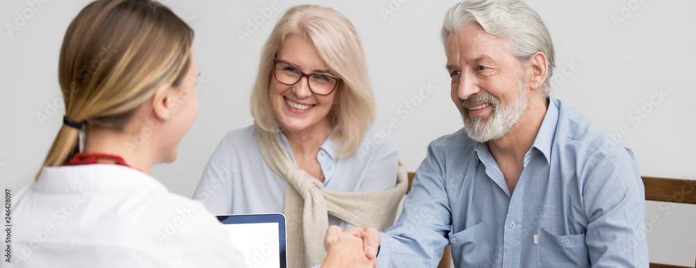 Horizontal photo grey-haired couple aged family meet with real estate agent in office greeting make deal shake hands buy home, leasing bank insurance services concept, banner for website header design Horizontal photo grey-haired couple aged family meet with real estate agent in office greeting make deal shake hands buy home, leasing bank insurance services concept, banner for website header design