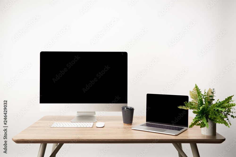 Fototapeta premium workplace with desktop computer and laptop with copy space on wooden table isolated on white