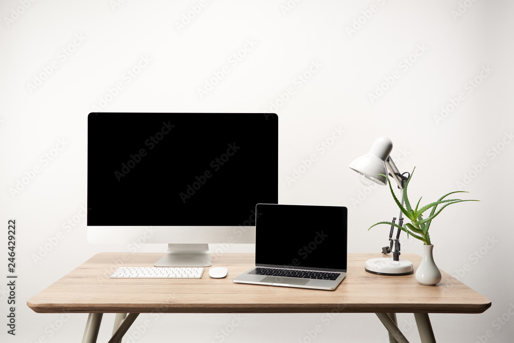 Fototapeta premium workplace with lamp, desktop computer and laptop with copy space isolated on white