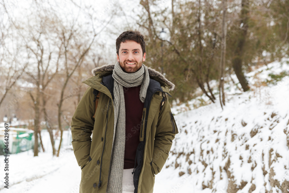 Fototapeta premium Handsome smiling young man wearing winter jacket