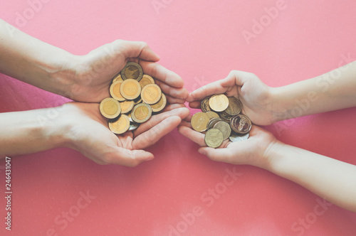 hands with coins on pink background for business and financial concept.