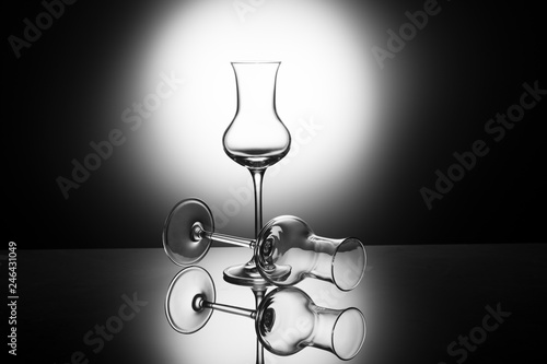 Fotografia, Obraz Two beautiful elegant shot glasses of grappa in the backlight, concept of empty