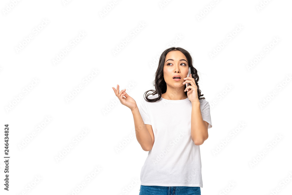Thoughtful asian girl in white t-shirt and blue jeans talking on smartphone isolated on white Thoughtful asian girl in white t-shirt and blue jeans talking on smartphone isolated on white