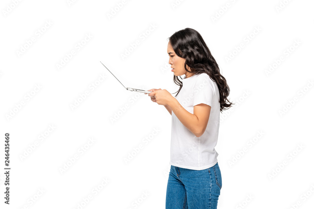 Angry young asian woman in white t-shirt and blue jeans using laptop isolated on white Angry young asian woman in white t-shirt and blue jeans using laptop isolated on white