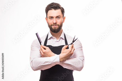 Bild auf Leinwand Portrait of bearded barber holding equipments in hand, looking at camera, isolat