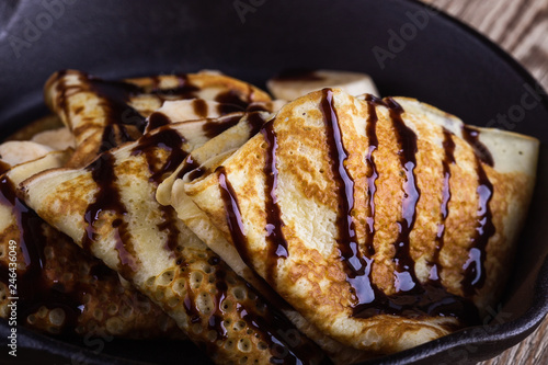 Crepes with bananas and chocolate topping for breakfast