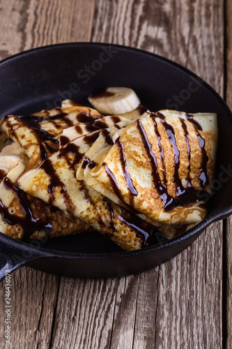 Crepes with bananas and chocolate topping for breakfast
