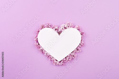 white heart decorated with lilac flowers on purple background. Card for Valentine's day, mother's day, women's day with love © Natalia