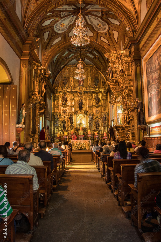 interior of an old cathedral in Mexico with details, engravings and altar in gold