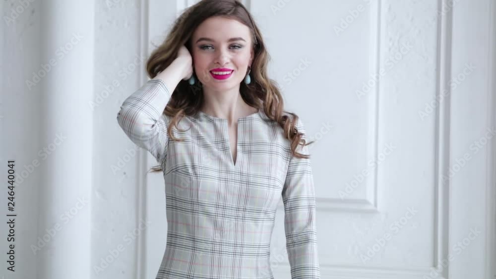 elegant girl model in grey plaid dress smiling and posing on white, slow motion elegant girl model in grey plaid dress smiling and posing on white, slow motion