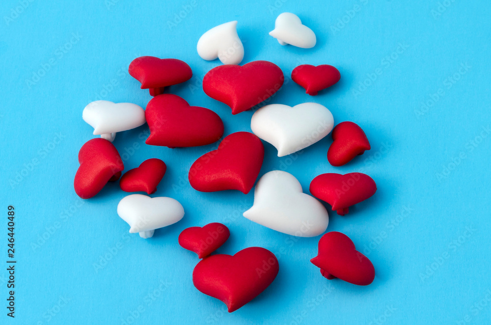 A few of red and white little hearts against blue background A few of red and white little hearts against blue background